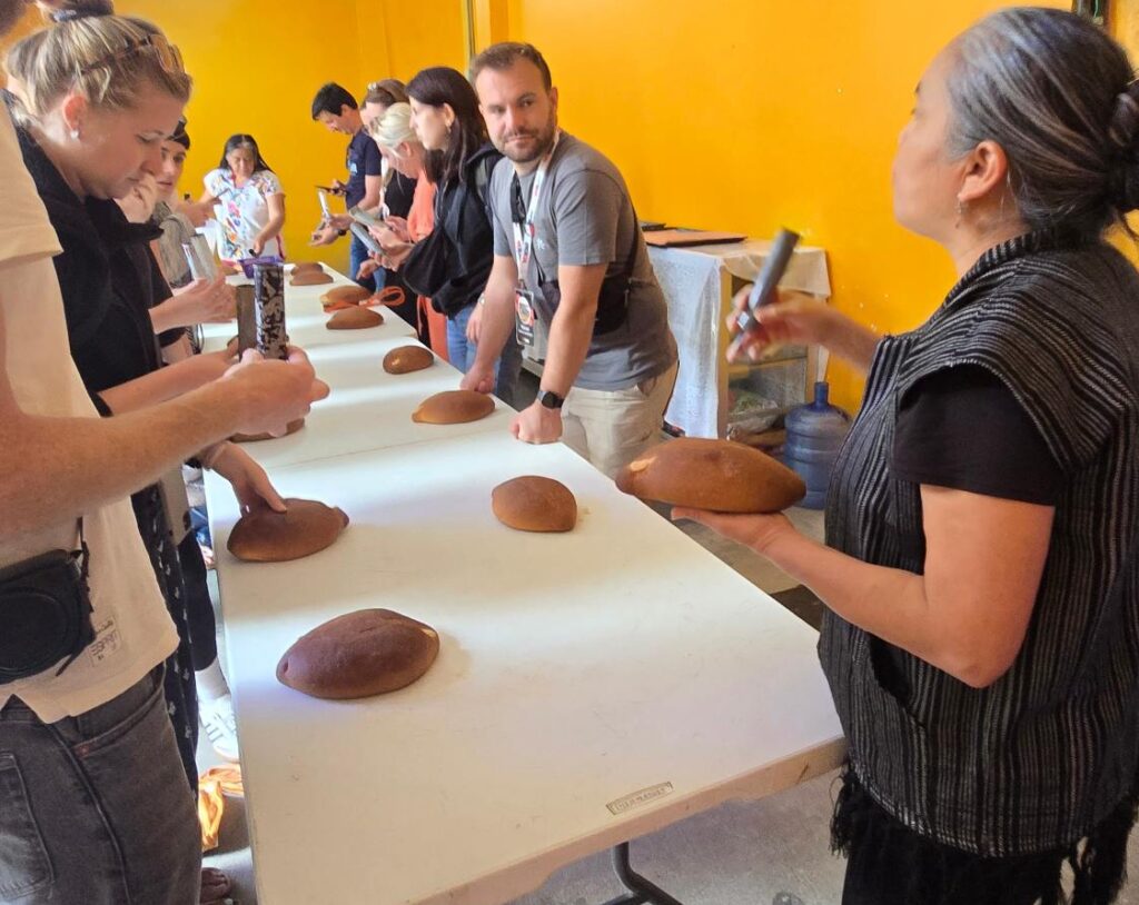 Día de Muertos en Mitla, Oaxaca: Viaje al Corazón de "La Ciudad de los Muertos" Taller Experiencial: Pinta tu propio Pan de Muerto El pan de muerto en Mitla es único en todo México. Aquí no se espolvorea con azúcar; se decora artísticamente a mano con un betún blanco tradicional, creando figuras y flores espectaculares. En nuestro tour, visitarás un taller local donde aprenderás a pintar tu propio pan guiado por maestros panaderos locales. ¡Una delicia visual y al paladar!